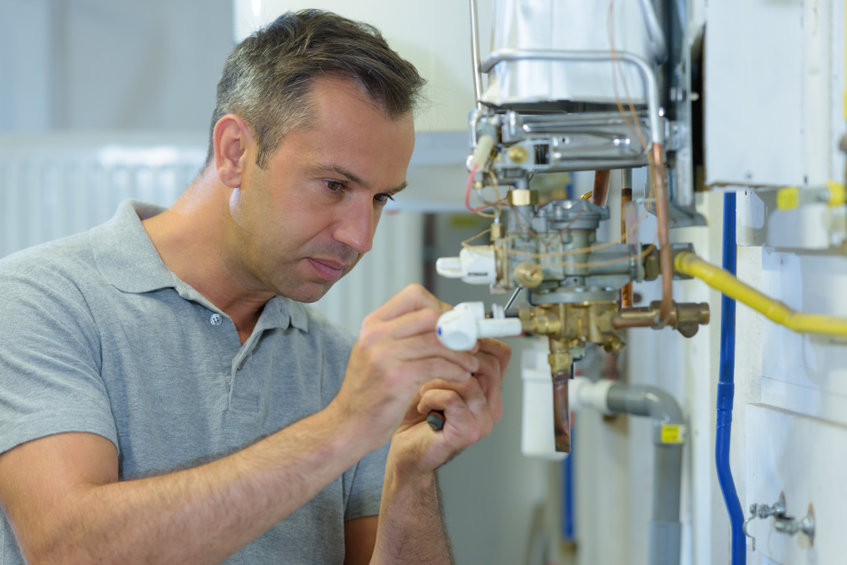 male engineer repairing a gas boiler